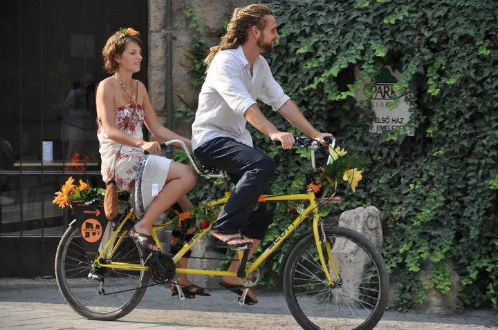 Arriving at the wedding on a yellow tandem bicycle.