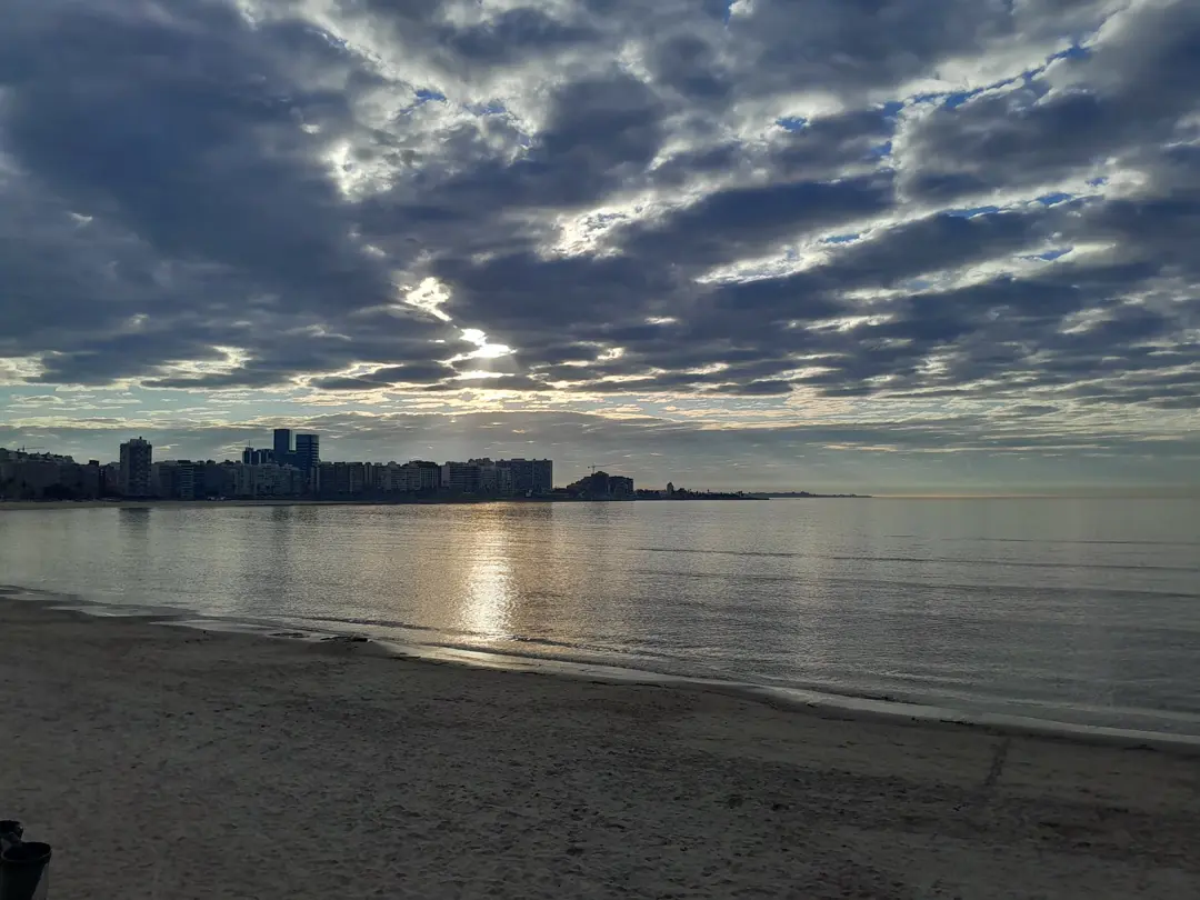 Pocitos bay and its towers, sun breaking through clouds over the river.